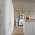 Окрашенная белая кирпичная стена имеет интересную текстуру, однако выглядит не столь брутально как голый бетон, и является своеобразным переходом от белой кухонной мебели к не окрашенной стене и голому бетонному потолку.