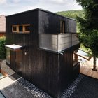 Компактный черный дачный домик с двумя спальнями на 35-ти квадратных метрах земли.