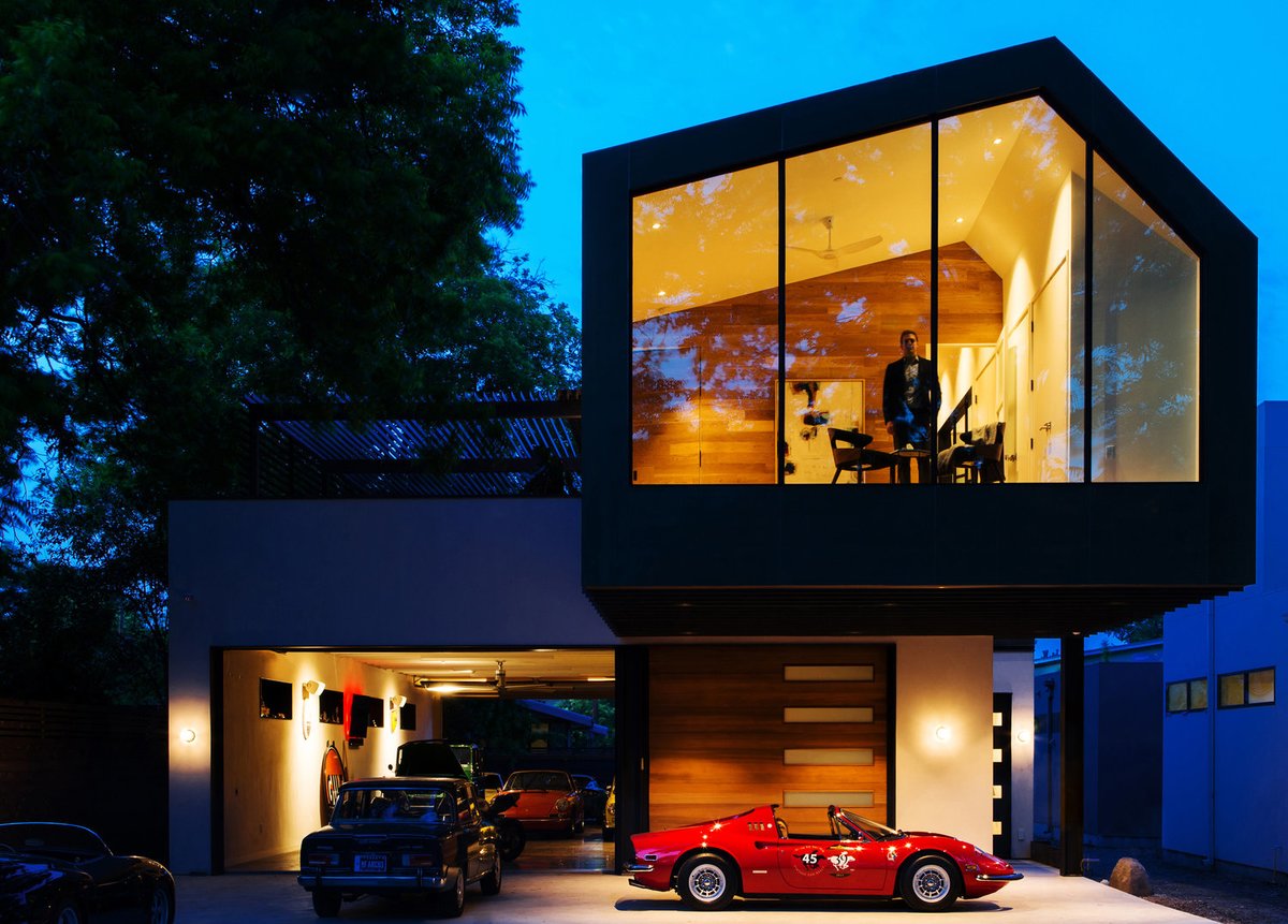 Эффектная подсветка дома подчеркивает его красоту и красоту машин владельца дома.