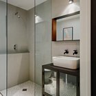 Вторая ванная комната оформлена более сдержано. Стены светло-серые бетонные, на полу кафельная плитка.