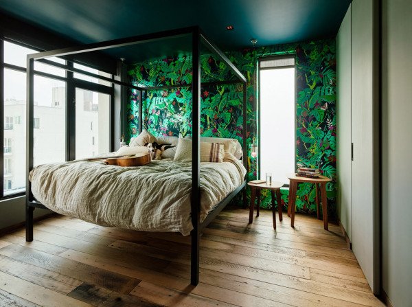 Темные зеленые тона и растительные орнаменты доминируют в отделке стен спален, что в сочетании с цветом натурального дерева создает расслабляющую атмосферу. Кровать из профильной трубы изготовлена на заказ.
