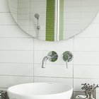 Светлая ванная комната с зелеными и серыми акцентами в отделке.