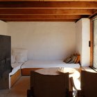 В роли диванов в гостиной использованы две деревянные кровати с подушками.