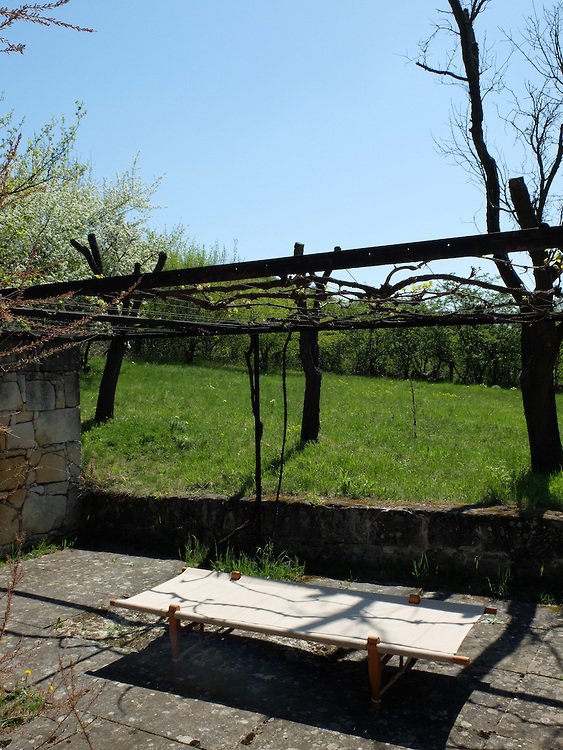 Двор покрыт каменными плитами. Над двором натянута сетка для винограда.