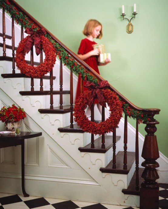 Красные праздничные венки как часть декора лестницы.