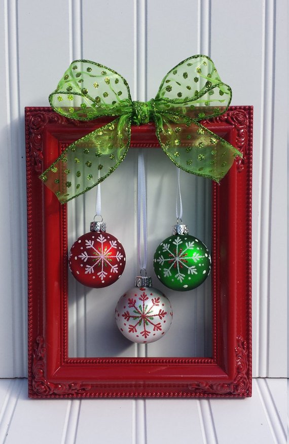 Совершенно необычная рождественская композиция из красной рамы с елочными шарами и зеленым бантиком, которую язык не поворачивается назвать венком.