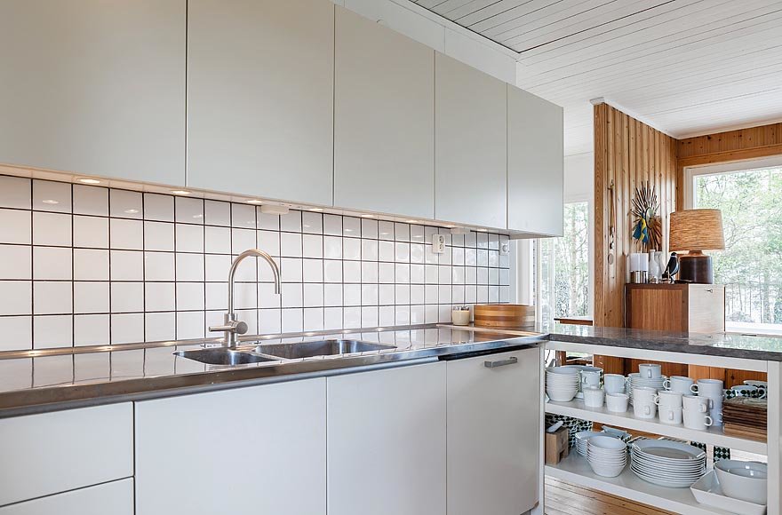 Кухня, как это часто бывает в скандинавских домах, нейтрально белая с простым белым кафелем.
