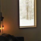 Окно в гостиной напоминает картину с живым зимним пейзажем.