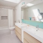 Детская ванная комната с мансардным окном в потолке и яркими акцентами подчеркивающими то что это детская ванна.