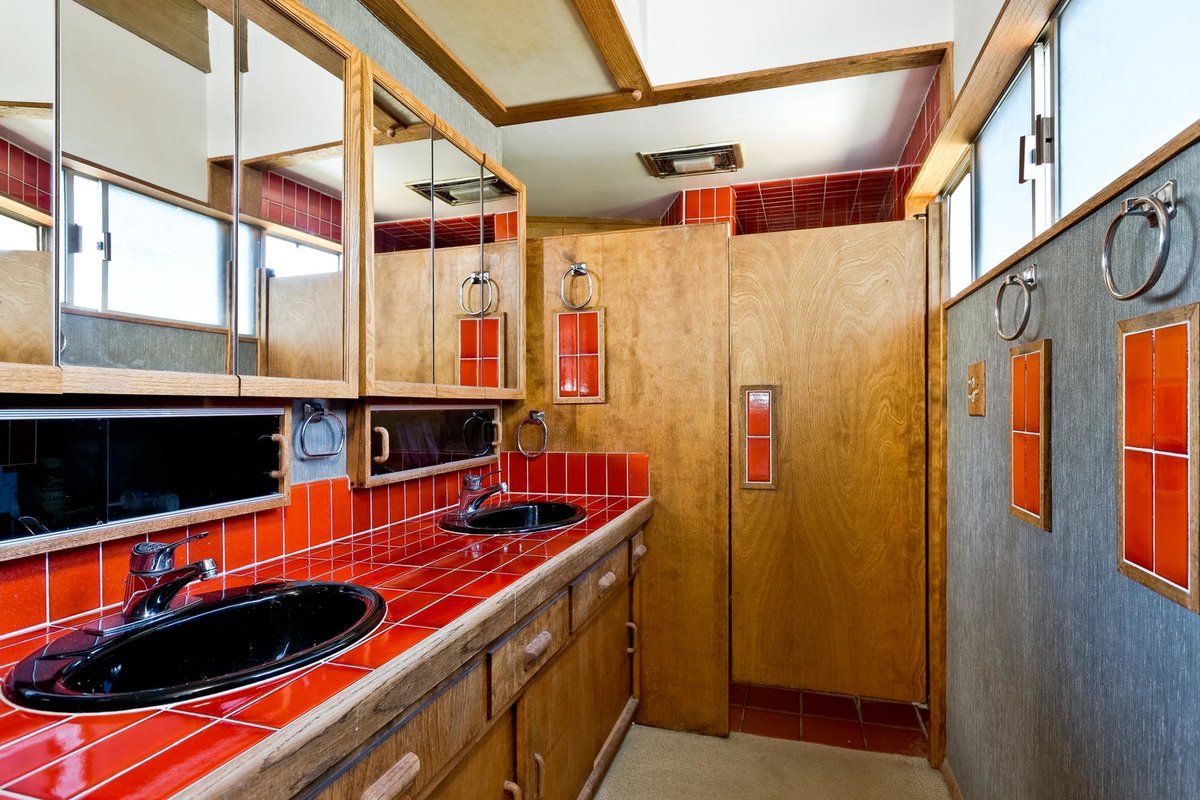 Ванная комната рядом с главной спальней. Столешница отделана красным кафелем, как и на кухне. Окно в верхней части хорошо освещает помещение. Душ отделен от ванной комнаты деревянной дверью