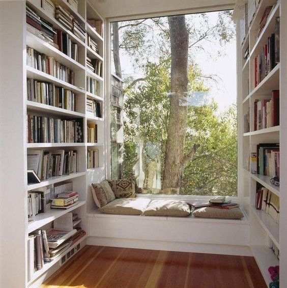 Широкий подоконник с несколькими подушками станет удобным местом для чтения в библиотеке