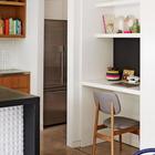 В кухонную мебель можно встроить стол и полки домашнего офиса.
