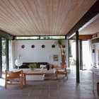 Натуральные цвета гостиной с белыми побеленными стенами, деревянным потолком делают интерьер приятными и ненадоедающим.