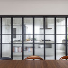 Перегородка из стекла и металла между кухней и столовой очень соответствует атмосфере квартиры.